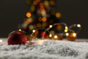 Eine Weihnachtskugel im Schnee mit Lichterketten